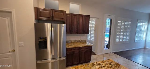 a kitchen with granite countertop wooden cabinets a stove and a window