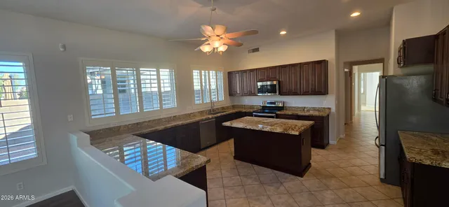 a kitchen with granite countertop stainless steel appliances a refrigerator and a sink