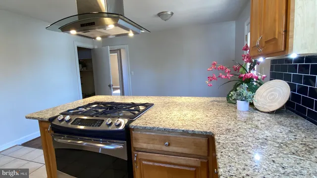 a kitchen with a stove and chandelier