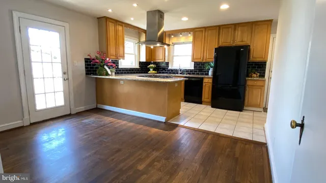 a kitchen with stainless steel appliances a refrigerator sink and wooden floor