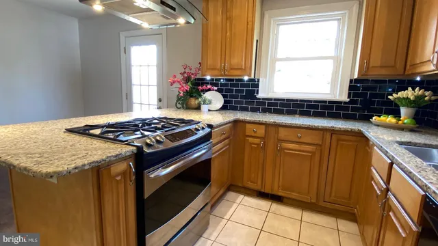 a kitchen with granite countertop a sink stainless steel appliances a window and a counter top space