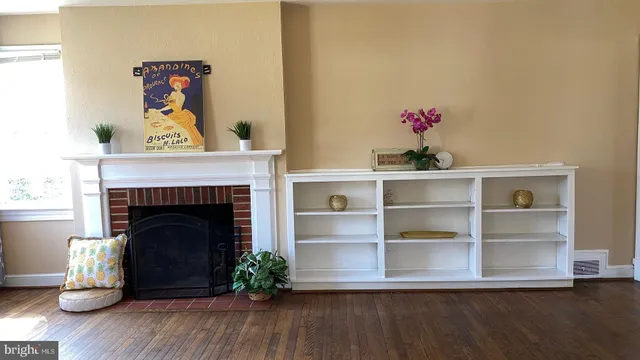 a living room with a fireplace and wooden floor