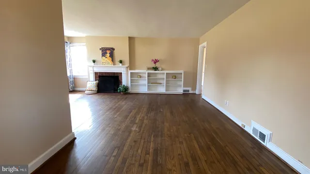 a view of a livingroom with wooden floor and a fireplace
