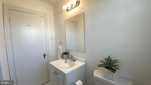a bathroom with a toilet a sink and mirror