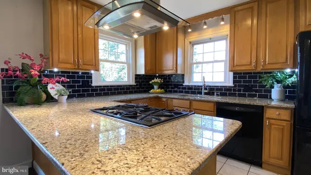 a kitchen with stainless steel appliances granite countertop a sink window and cabinets