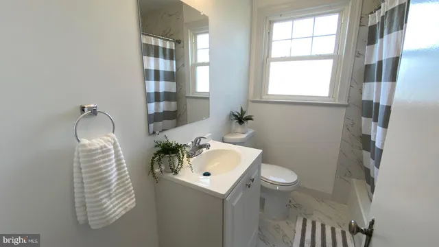 a bathroom with a sink toilet and window
