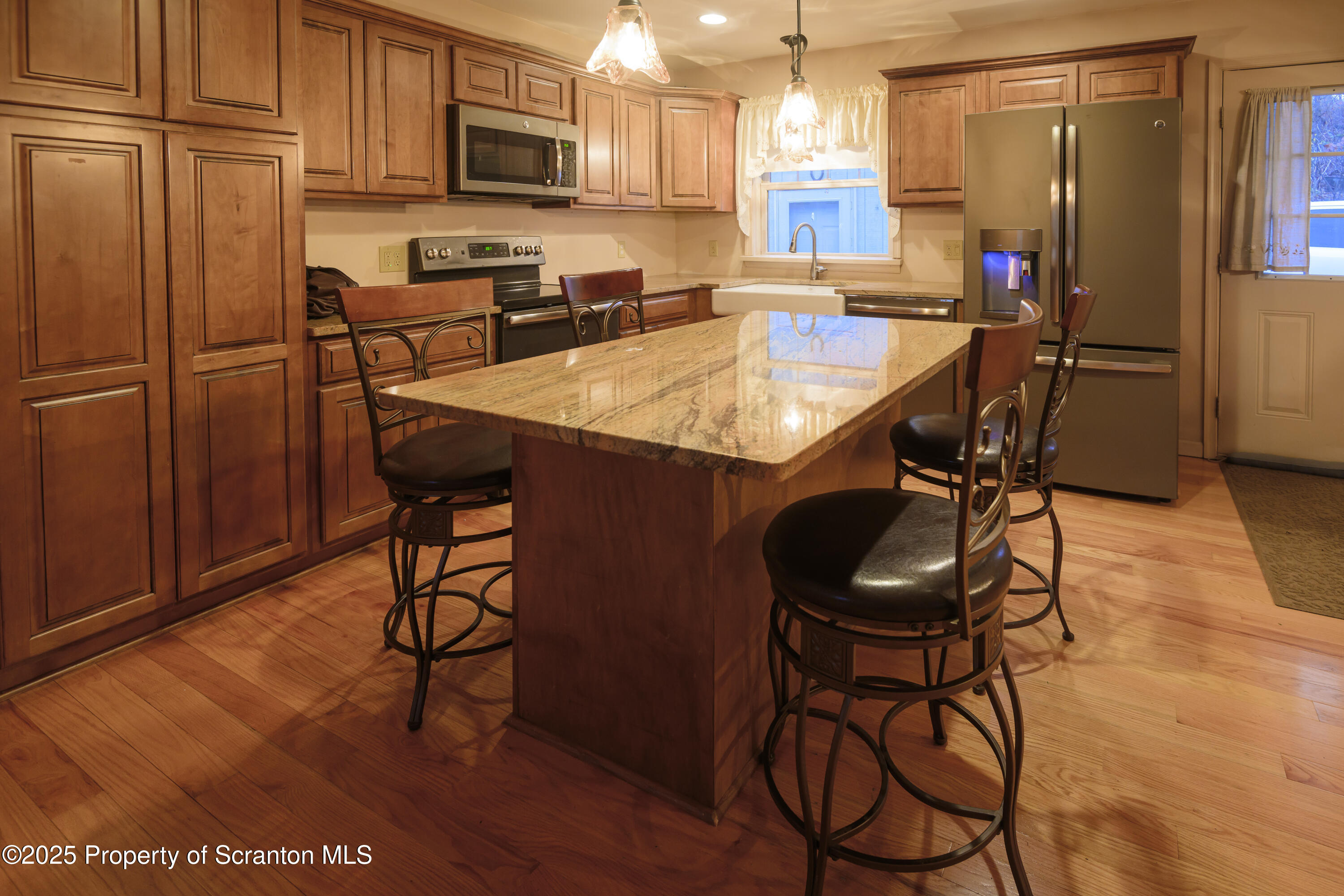 159 Vail Road Factoryville, PA 18419 - Photo 6 of 31 a kitchen with stainless steel appliances granite countertop a stove a refrigerator a sink a dining table and chairs with wooden floor
