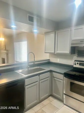 a kitchen with white cabinets appliances and a sink