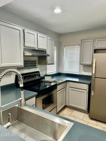 a kitchen with granite countertop a sink cabinets and stainless steel appliances