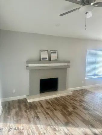 a view of empty room with wooden floor and fireplace