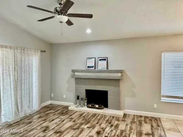 a view of an empty room with a fireplace and a window