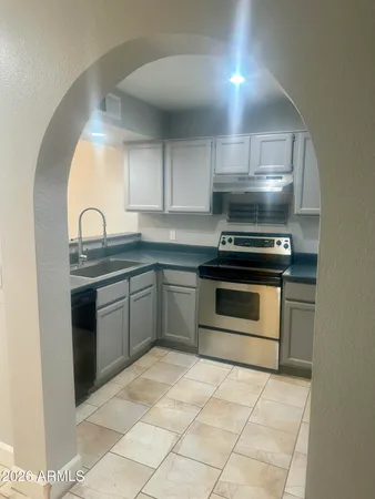 a kitchen with granite countertop a stove a sink and a microwave