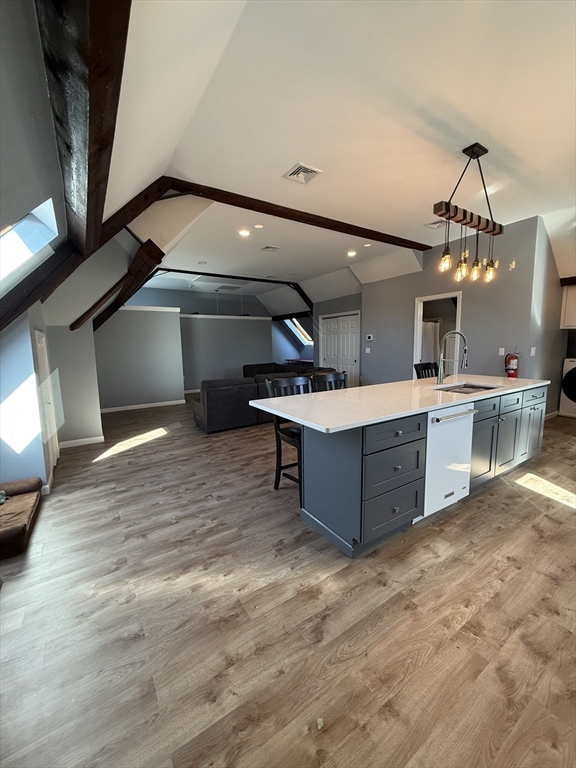 10 High Street, Unit 3 Andover, MA 01810 - Photo 5 of 16 a room with kitchen island stainless steel appliances a wooden floor and a view of living room
