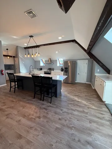 a view of a big room with wooden floor fire place and furniture