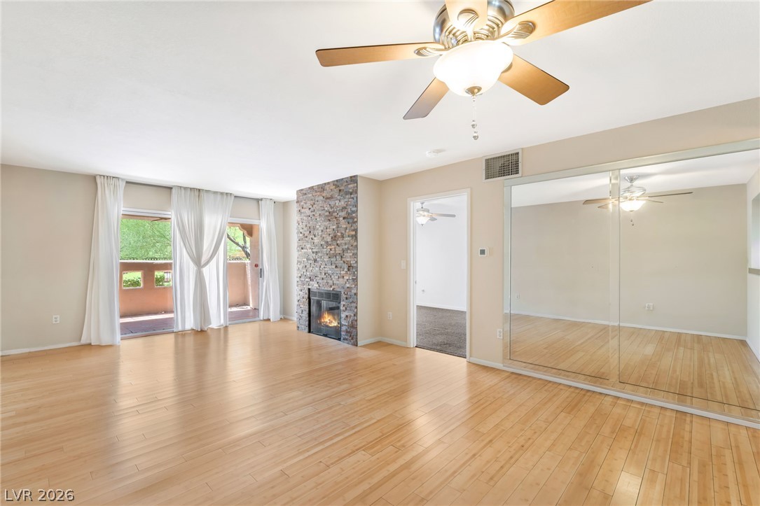 1901 Rio Canyon Court, Unit 102 Las Vegas, NV 89128 - Photo 8 of 23 Luminous living area features gleaming wood floors, a stylish fireplace, and direct patio access.