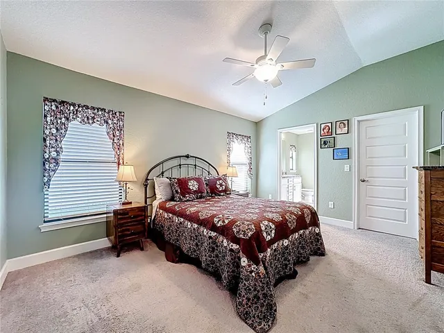 a bedroom with a bed next to a window and a chandelier