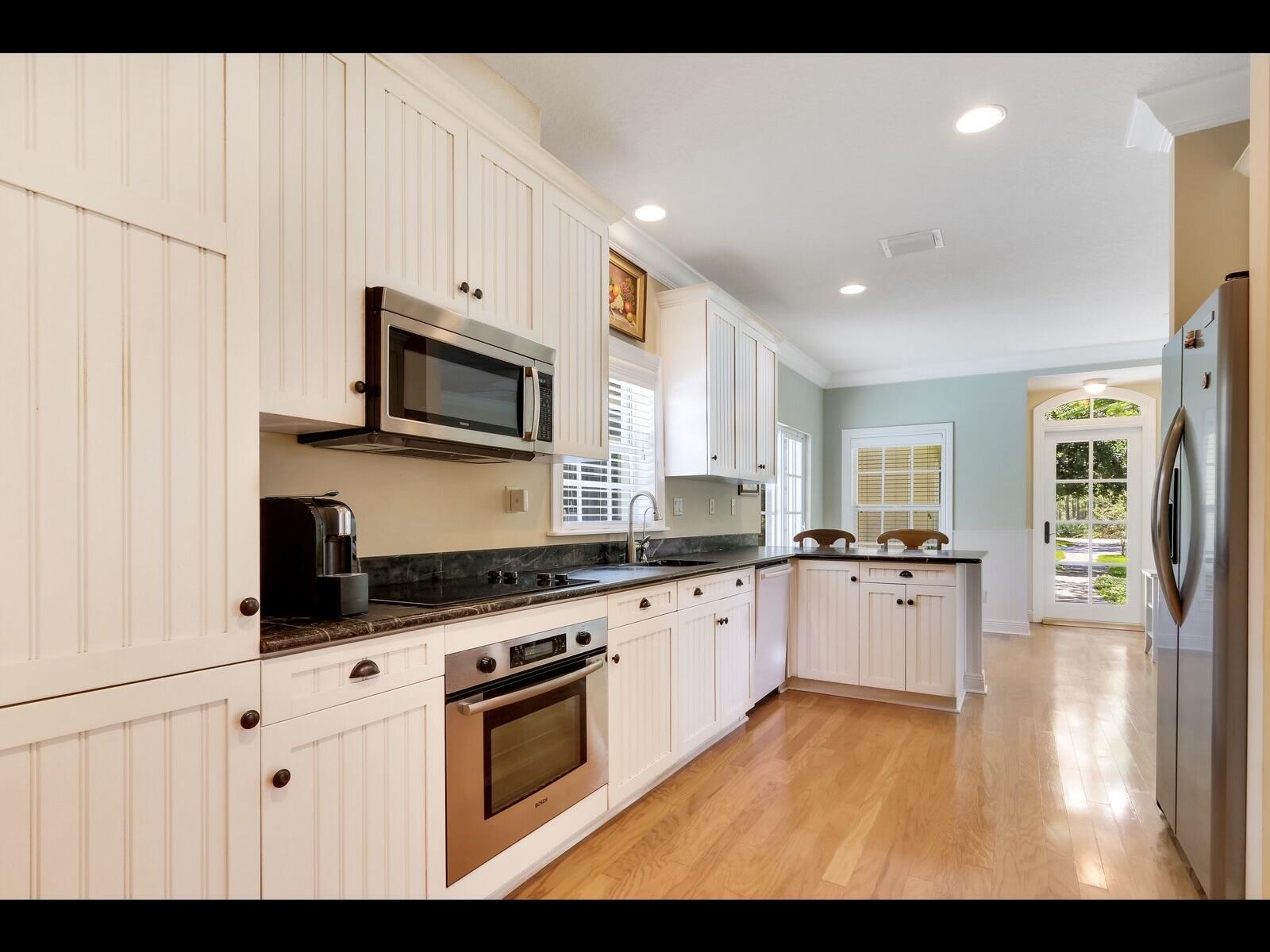 1856 Southeast Colony Way Jupiter, FL 33478 - Photo 2 of 10 a kitchen with granite countertop a stove top oven sink and cabinets