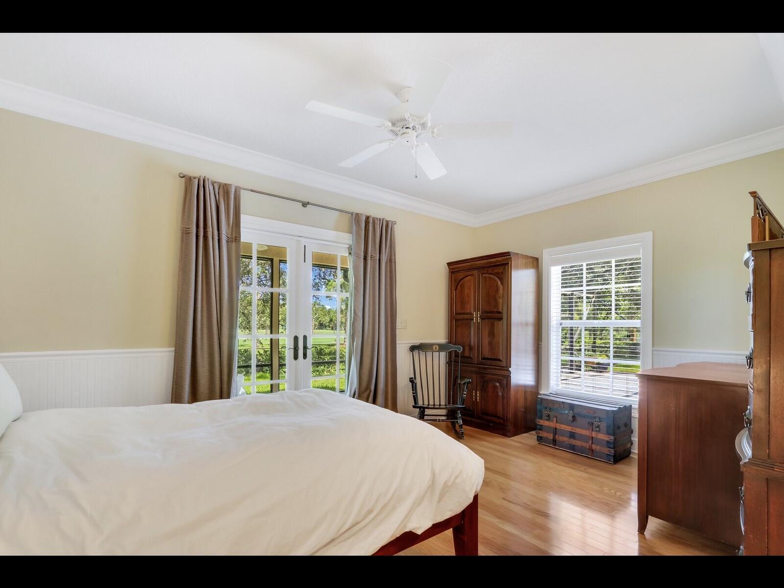 1856 Southeast Colony Way Jupiter, FL 33478 - Photo 6 of 10 a bedroom with a large bed and wooden floor