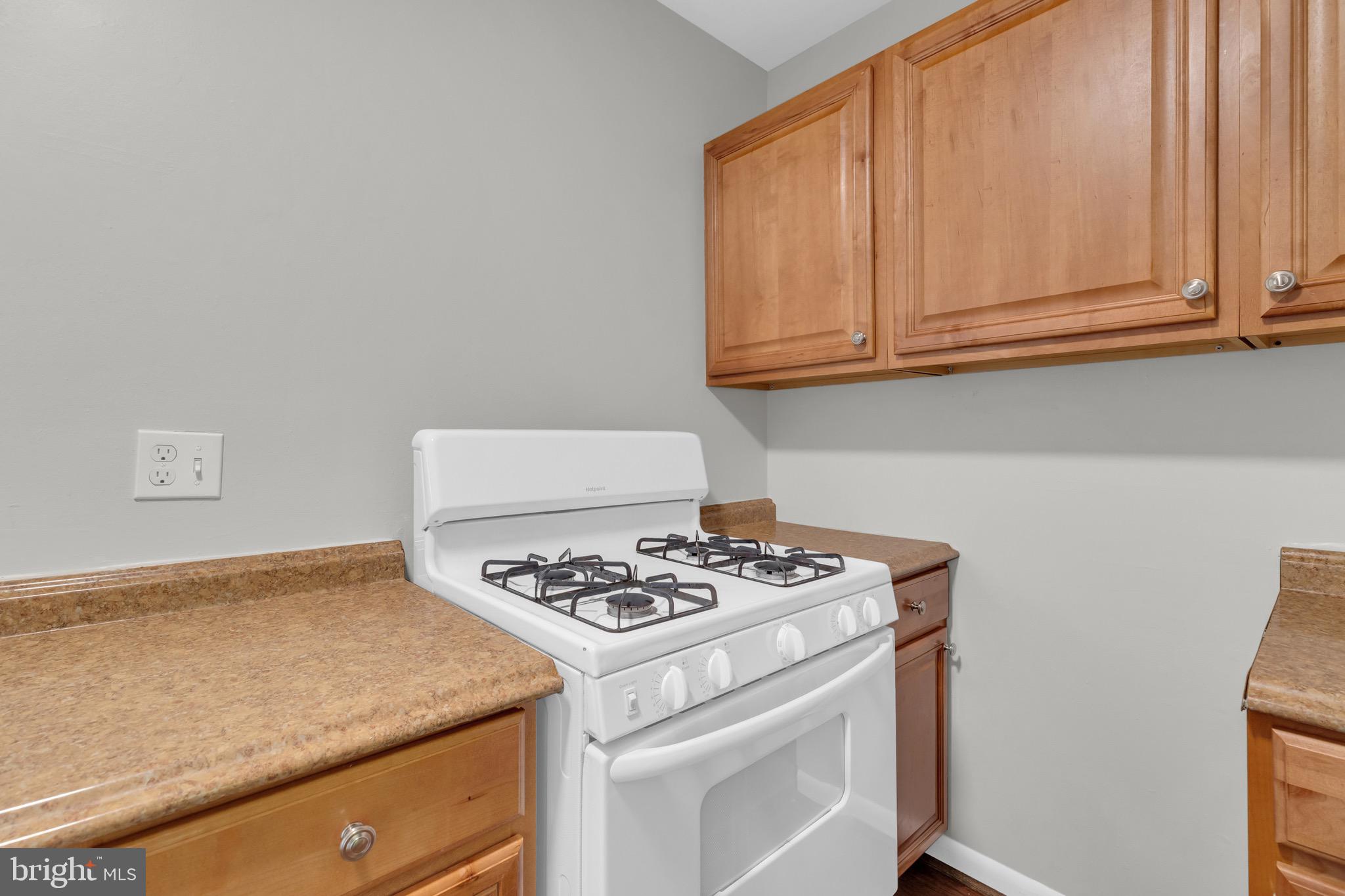 11620 Vantage Hill Road, Unit 22B Reston, VA 20190 - Photo 16 of 24 a kitchen with granite countertop white cabinets stove and sink