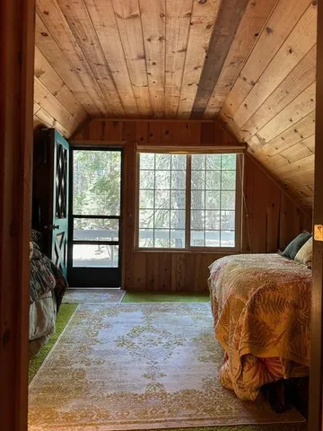 a bed sitting in a spacious bedroom next to a window