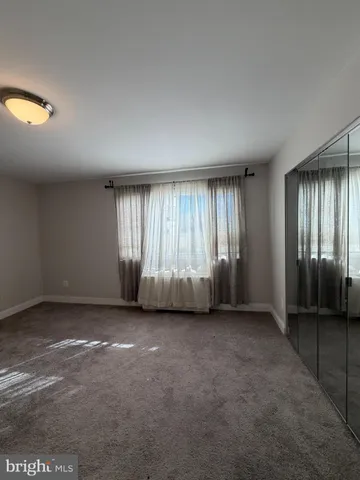 an empty room with closet and windows