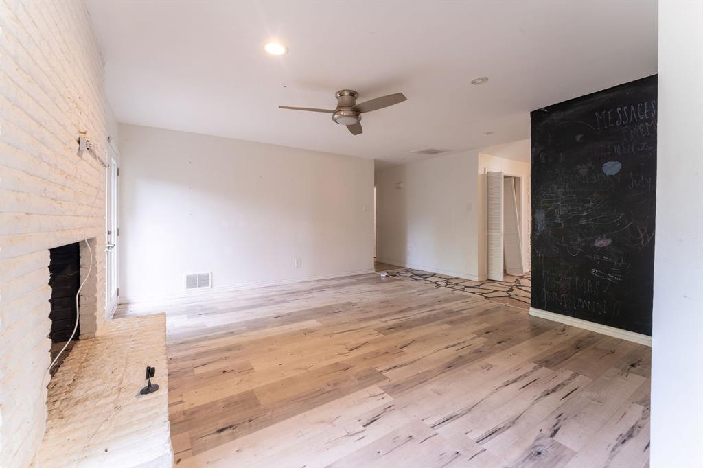 9797 Broken Bow Road Dallas, TX 75238 - Photo 16 of 16 an empty room with wooden floor and fireplace