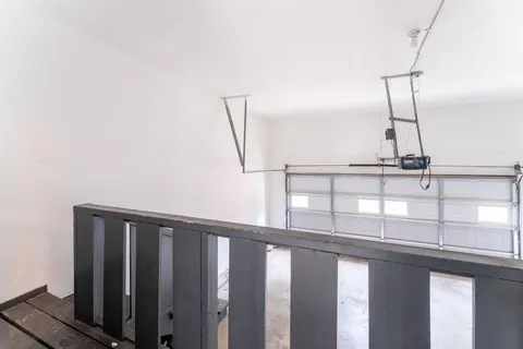 a view of staircase with railing and white walls