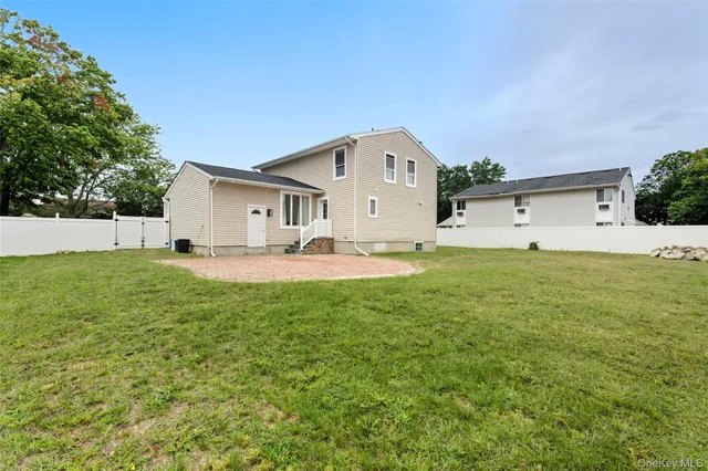 a front view of house with yard and trees in the background