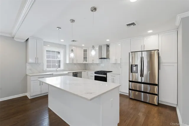 a kitchen with stainless steel appliances granite countertop a refrigerator a sink and a stove