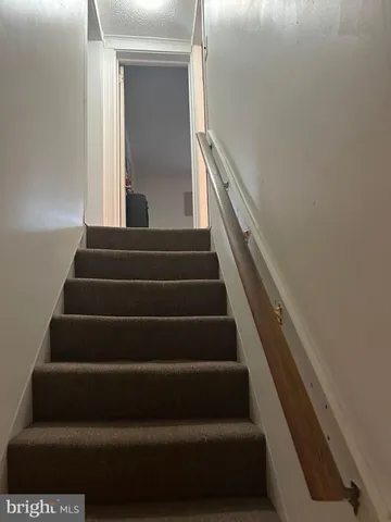 an empty room with windows and chandelier fan