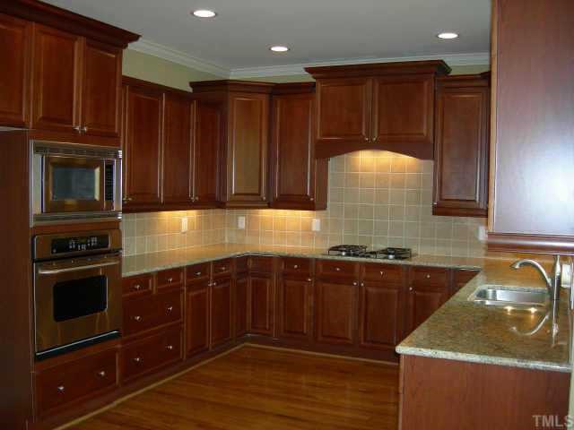 11519 Azari Court Raleigh, NC 27614 - Photo 3 of 10 a kitchen with wooden cabinets and a sink