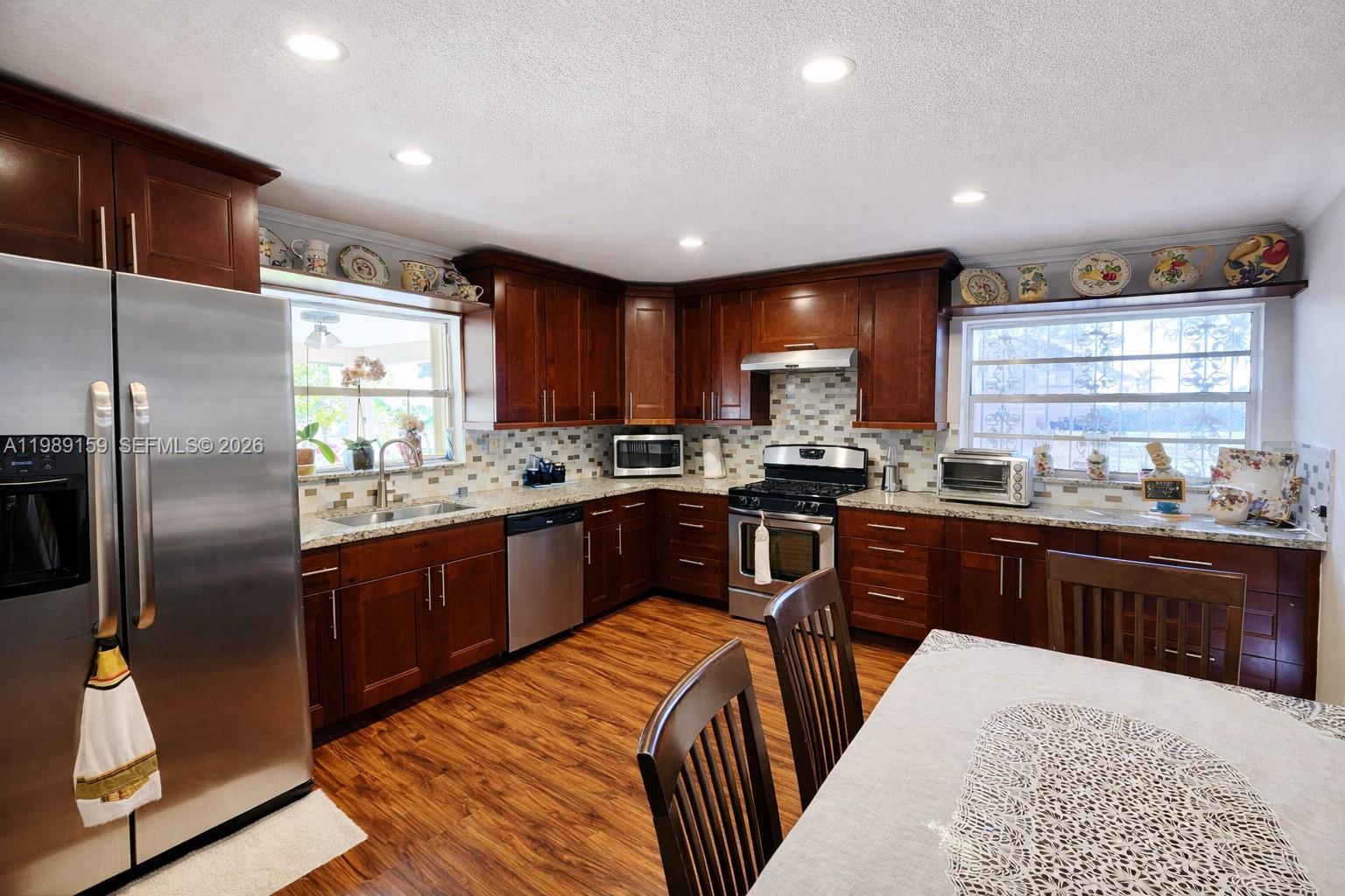7344 Southwest 135th Court Miami, FL 33183 - Photo 3 of 24 a kitchen with stainless steel appliances granite countertop a refrigerator a sink dishwasher a stove and oven with wooden floor