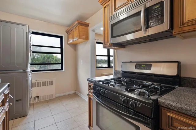 a kitchen with stainless steel appliances granite countertop white cabinets and a stove top oven