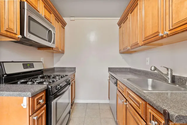 a kitchen with stainless steel appliances granite countertop a sink a stove and a microwave