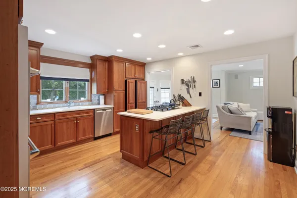 a spacious kitchen with stainless steel appliances granite countertop a lot of counter space and a wooden floors