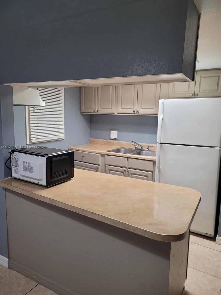 2775-l B L B McLeod Road, Unit B Orlando, FL 32805 - Photo 13 of 28 a kitchen with a white cabinets and refrigerator