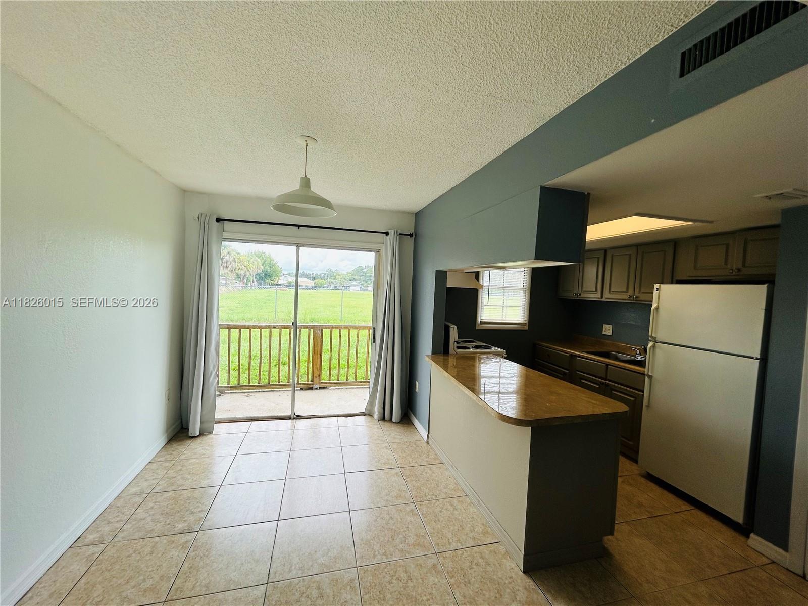2775-l B L B McLeod Road, Unit B Orlando, FL 32805 - Photo 3 of 28 a kitchen with refrigerator and chair