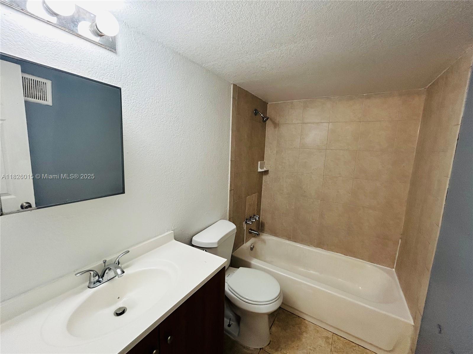 2775-l B L B McLeod Road, Unit B Orlando, FL 32805 - Photo 7 of 13 a bathroom with a bathtub shower sink vanity mirror and toilet