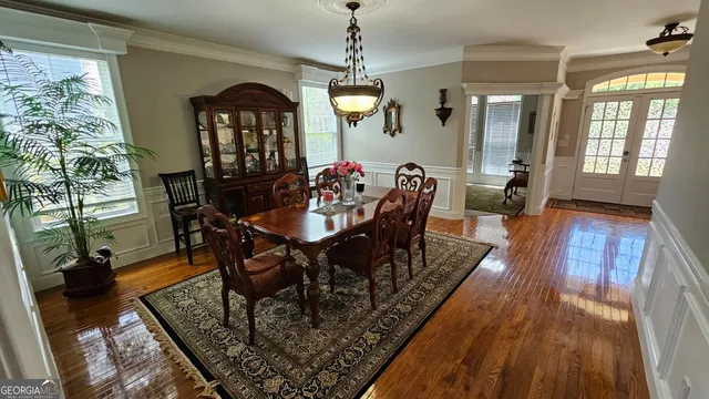 a living room with stainless steel appliances furniture a rug kitchen view and a chandelier