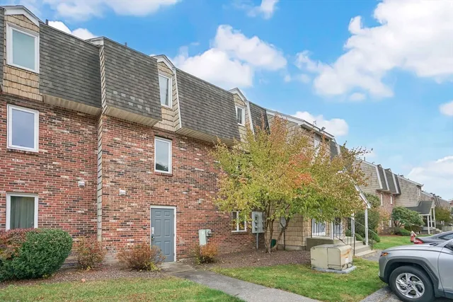 a front view of a house with a garden and trees