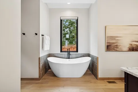 a bathroom with double vanity and a bathtub