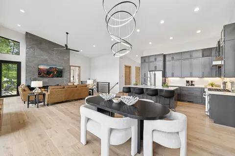 a living room with furniture kitchen view and a large window