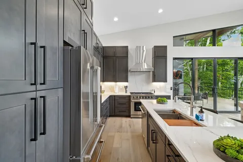 a kitchen with stainless steel appliances granite countertop a refrigerator a sink dishwasher and a stove