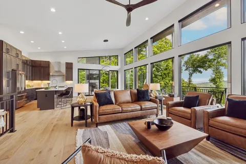 a living room with furniture a fireplace and a large window