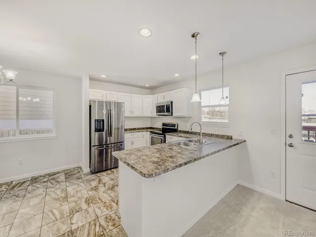 a kitchen with a refrigerator sink and cabinets