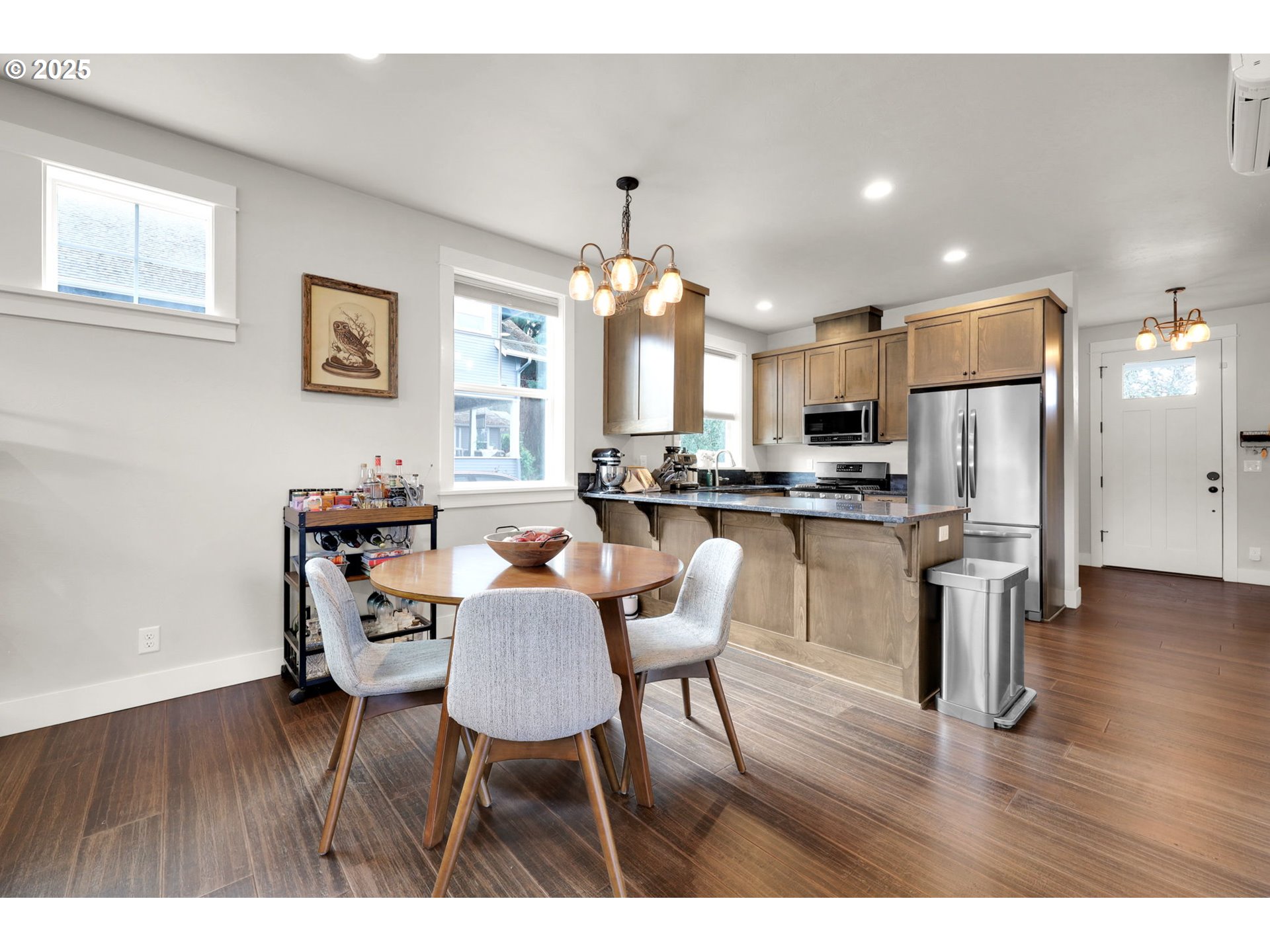2819 Adams Street Eugene, OR 97405 - Photo 16 of 44 a kitchen with a dining table chairs refrigerator and cabinets