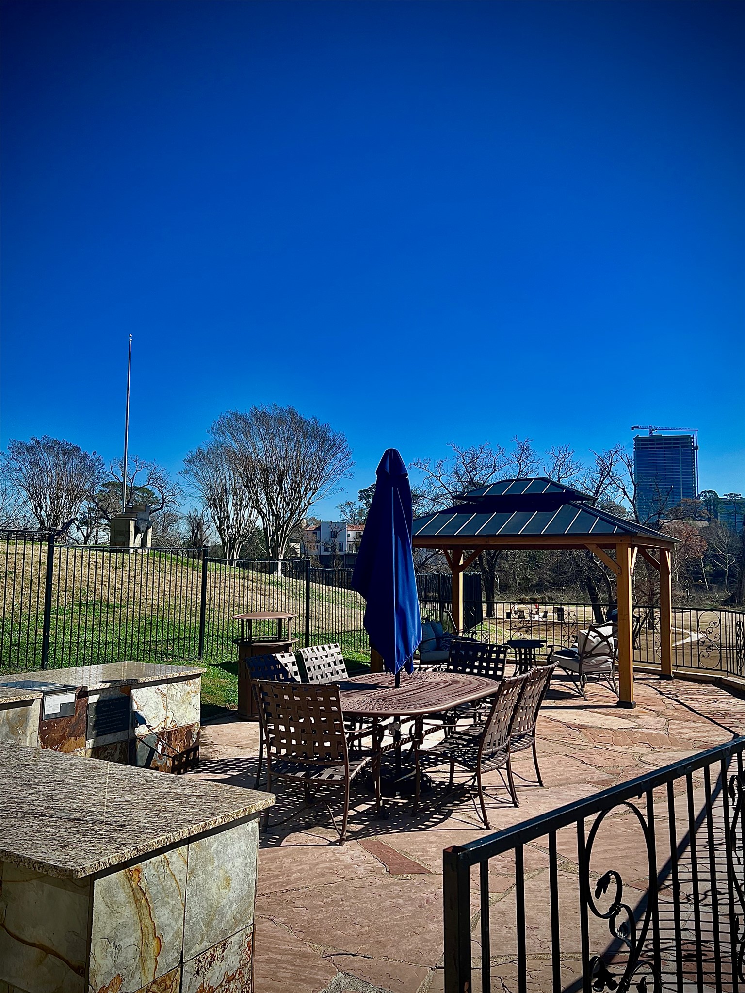 5353 Memorial Drive, Unit 3038 Houston, TX 77007 - Photo 19 of 27 a view of a patio with couches table and chairs under an umbrella with a small yard