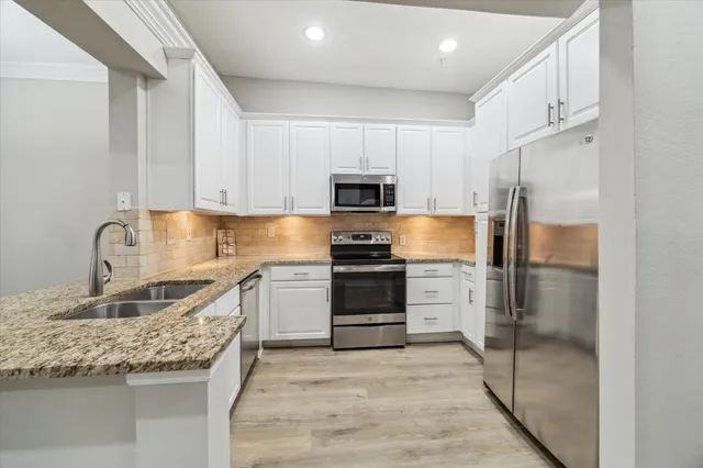 a kitchen with granite countertop a refrigerator and a sink