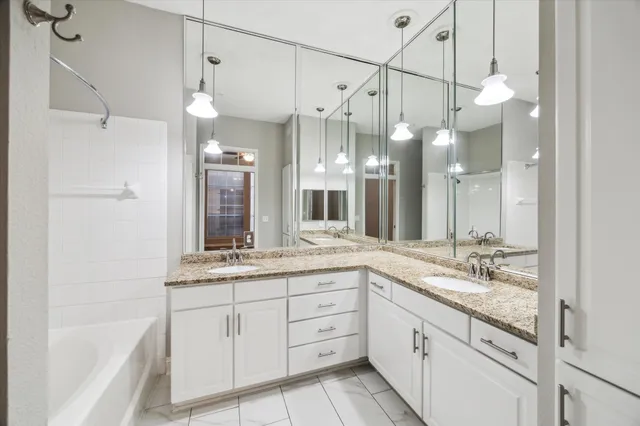 a spacious bathroom with a granite countertop sink mirror and a shower