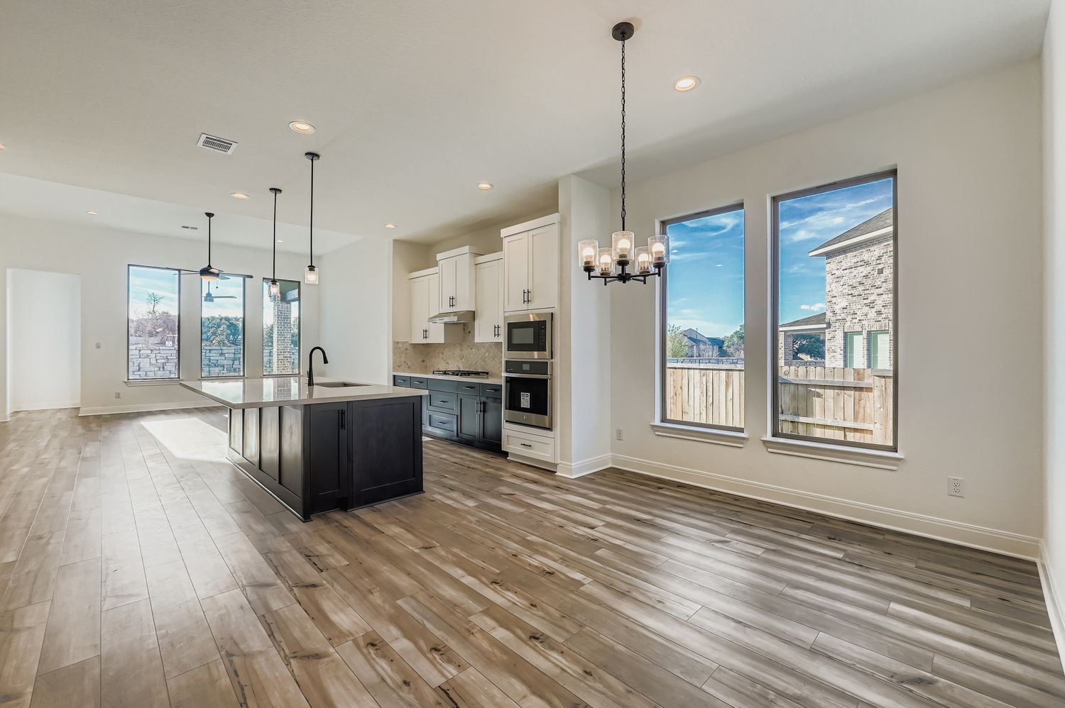 480 Prickly Poppy Loop Kyle, TX 78640 - Photo 3 of 11 a large kitchen with stainless steel appliances kitchen island a large counter top and wooden floors